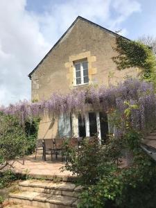 a house with purple wisterias on the side of it at Maison de charme en Bourgogne in Coulanges-lès-Nevers