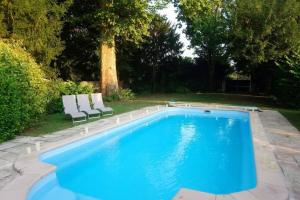 a swimming pool with two lounge chairs next to it at Maison de charme en Bourgogne in Coulanges-lès-Nevers