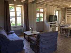 Maison de charme en Bourgogne في Coulanges-lès-Nevers: غرفة معيشة مع أريكة وطاولة