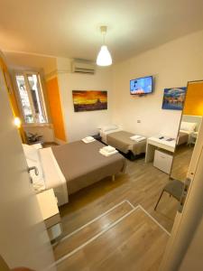 a hotel room with two beds and a tv at B&B A Home in Rome in Rome