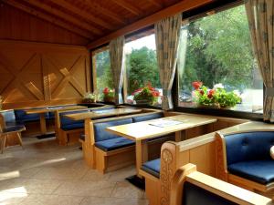a restaurant with tables and chairs and large windows at Active Hotel Pineta in Baselga di Pinè +50 photos