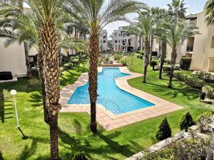 an image of a swimming pool in a yard with palm trees at Apartamento Almyra Roda Golf in San Javier