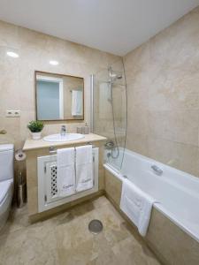ein Badezimmer mit einer Badewanne, einem Waschbecken und einem WC in der Unterkunft Apartamento Almyra Roda Golf in San Javier