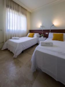 ein Hotelzimmer mit 2 Betten und einem Fenster in der Unterkunft Apartamento Almyra Roda Golf in San Javier