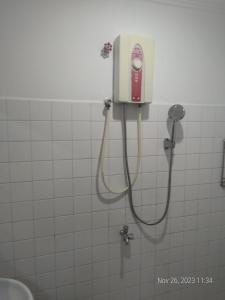 a shower in a bathroom with a phone on the wall at Rhythm Bollywood Guesthouse in Phnom Penh