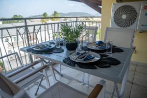 una mesa azul con platos y servilletas en el balcón en L'élégance citadine en Cayenne