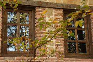 three windows on a brick building with a tree at Chateau Orberi in Ikalto