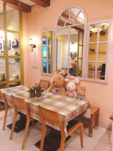 three stuffed teddy bears sitting on a dining room table at 洄瀾雅舍民宿-近火車站-東大門夜市附近 in Hualien City