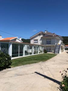 a white house with a porch and a driveway at Villa Abreu in Esposende