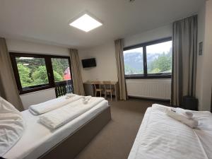 a hotel room with two beds and a table at Stubnerhof in Bad Gastein