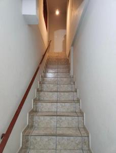 Un escalier mène à une chambre aux murs blancs. dans l'établissement Quarto Guararema 2, à Guararema