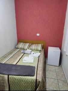 - une petite chambre avec un lit et des serviettes dans l'établissement Quarto Guararema 2, à Guararema