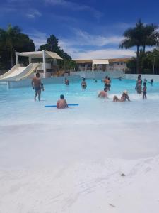 a group of people in the water on a beach at Proprietária in Caldas Novas