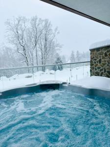 una vasca idromassaggio con neve per terra di Kras-Resort Apartament 113 a Szklarska Poręba
