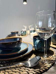 a table with plates and a glass of wine at Kras-Resort Apartament 113 in Szklarska Poręba