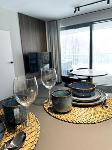 a table with plates and wine glasses on it at Kras-Resort Apartament 113 in Szklarska Poręba