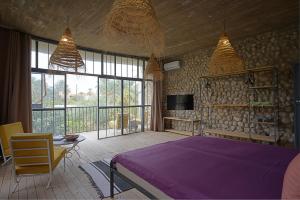 1 dormitorio con 1 cama de color púrpura y TV en dar seddik en Gafsa