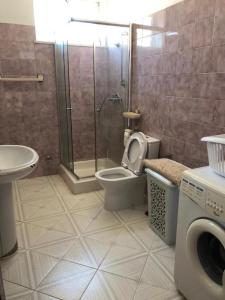 a bathroom with a shower and a toilet and a sink at Villa Abreu in Esposende
