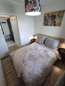 una camera da letto con un letto e un dipinto sul muro di ***Santorini Apartament*** - 40m² ✓ a Rybnik