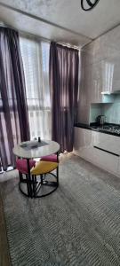 uma sala de estar com uma mesa e uma mesa e cadeiras em Квартира в новом жилом комплексе Mega Tower em Tashkent
