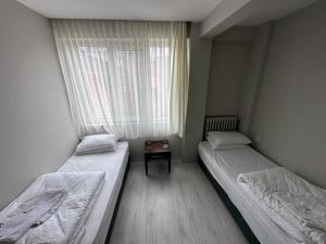 two twin beds in a room with a window at HOTEL KOCABASOGLU in Istanbul