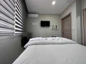 a bedroom with a large white bed and a tv at HOTEL KOCABASOGLU in Istanbul