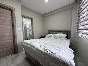 a bedroom with a bed with white sheets and a window at HOTEL KOCABASOGLU in Istanbul