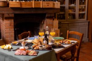 una mesa con comida y dos copas de vino en TORRE GIARDINO SEGRETO B&B- Borgo Capitano Collection - Albergo diffuso, en San Quirico dʼOrcia