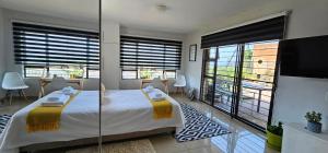 a bedroom with a bed and a large window at Your Happy Holiday Place in La Mercy