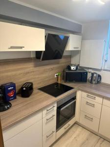 a kitchen with white cabinets and a black microwave at Ferienwohnung Klee in Arnsberg