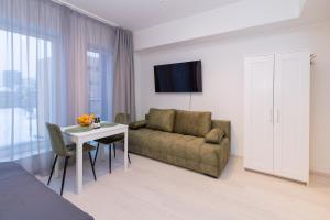 a living room with a couch and a table at Revalia Lastekodu Airport/Bus Station Studio in Tallinn