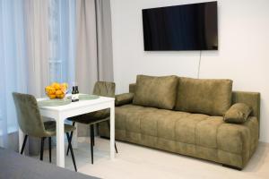 sala de estar con sofá y mesa en Revalia Lastekodu Airport/Bus Station Studio en Tallin