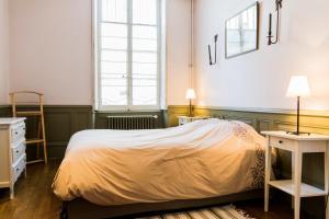 a bedroom with a bed and two tables and a window at Le Pasteur in Dijon