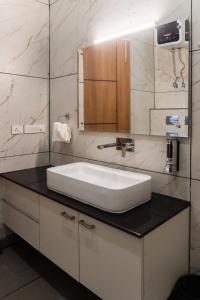 a bathroom with a white sink and a mirror at Sandane Homes By The Lodgers Near India Expo Centre & Mart Greater Noida in Greater Noida