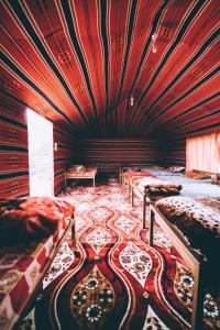 a room with two beds in a room with red ceilings at Khaled's Camp in Wadi Rum