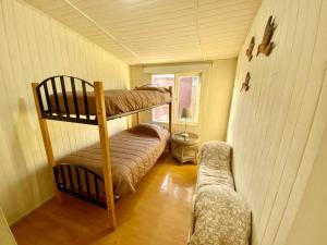 a small room with two bunk beds and a couch at Bahia Inglesa cabaña frente al mar WI-Fi satéliteTv agua caliente in Bahia Inglesa