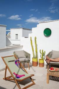 a patio with two chairs and a chaise lounge at Casa Antica Pietra Ostuni in Ostuni