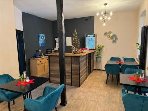 a restaurant with blue chairs and a counter with christmas decorations at Aneton Garni Hotel in Thale
