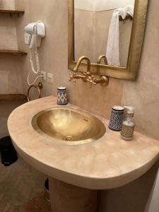 a sink in a bathroom with a mirror at Riad El Gnaouia in Marrakesh