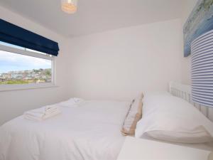 a white bedroom with a bed and a window at 3 Bed in Brixham 75230 in Brixham