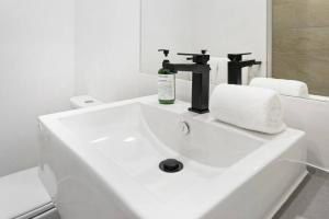ケアンズにあるCity Escape at Loft Apartments - Cairns CBDの白いバスルーム(洗面台、蛇口、タオル付) +30枚の写真