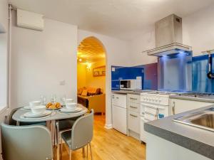 een keuken met een tafel en stoelen en een keuken met blauwe bij 2 bed property in Coleford 77702 in Staunton