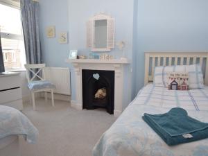 a bedroom with a bed with a fireplace and a mirror at 3 bed in Eastbourne EHC04 in Eastbourne