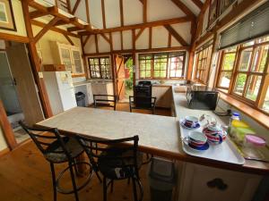 Bohemian Garden Cottages في Kaapsehoop: مطبخ مع طاولة وكراسي في منزل