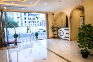 a lobby with a large glass door and potted plants at سارا للشقق الفندقية Sara Furnished Apartments in Al Khobar