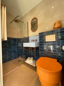 a bathroom with an orange toilet and a sink at Villa Chiesa in Le Grau-du-Roi