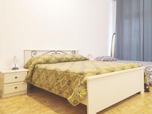Dormitorio blanco con cama con colcha amarilla en Trento Degasperi 16, en Trento