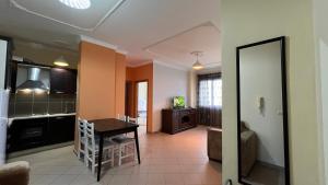 een woonkamer met een tafel en een keuken bij Mikael Apartment in Durrës