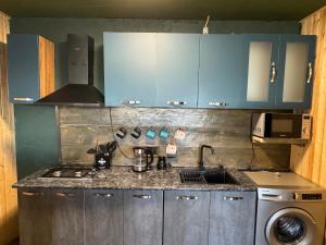 una cocina con armarios azules y fregadero en Gzaze en Stepantsminda