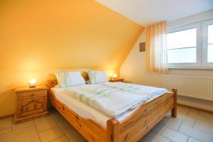 a bedroom with a large wooden bed with a window at J. Apfeld Ferienwohnungen in Borkum